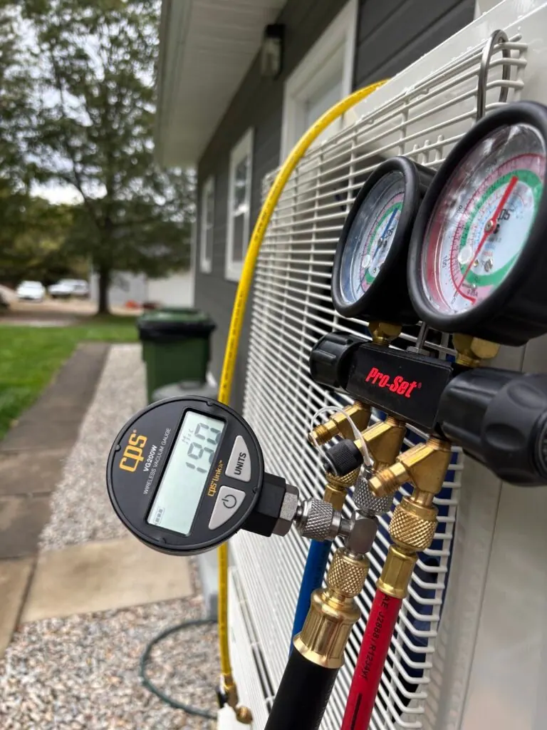 Digital vacuum gauge and manifold connected during heat pump commissioning
