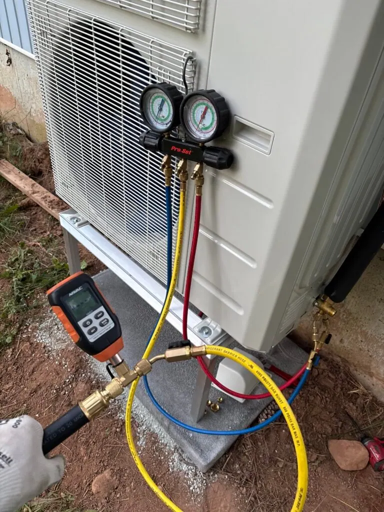 Technician pressure-testing a new heat pump installation